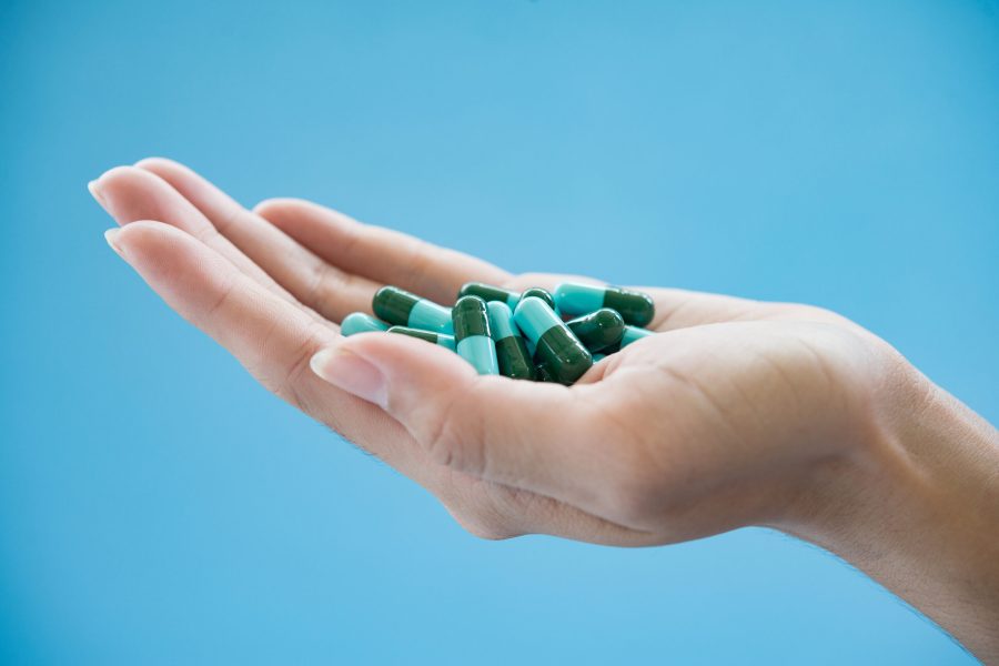 Woman's hand pours the medicine pills out of the bottle