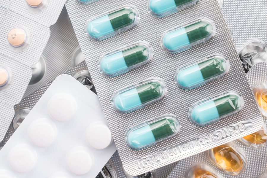 packings of pills and capsules of medicines on white background