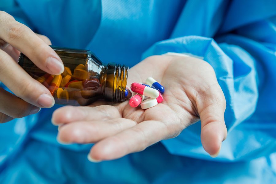 Woman's hand pours the medicine pills out of the bottle